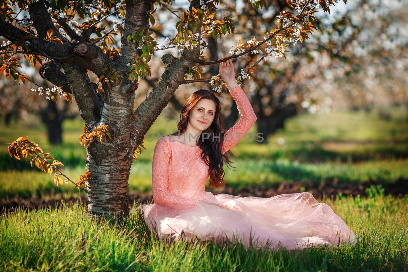 Portrait of a young beautiful girl in spring orchard