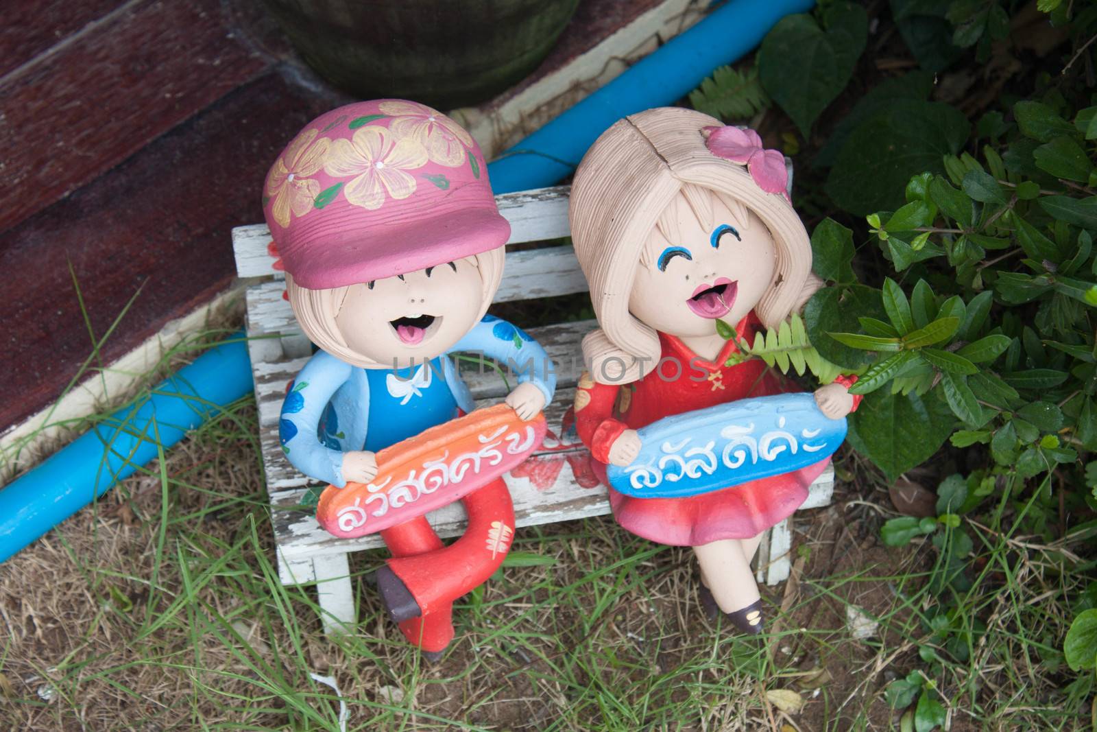 Child ceramic doll Holding signs that say hello Thailand.