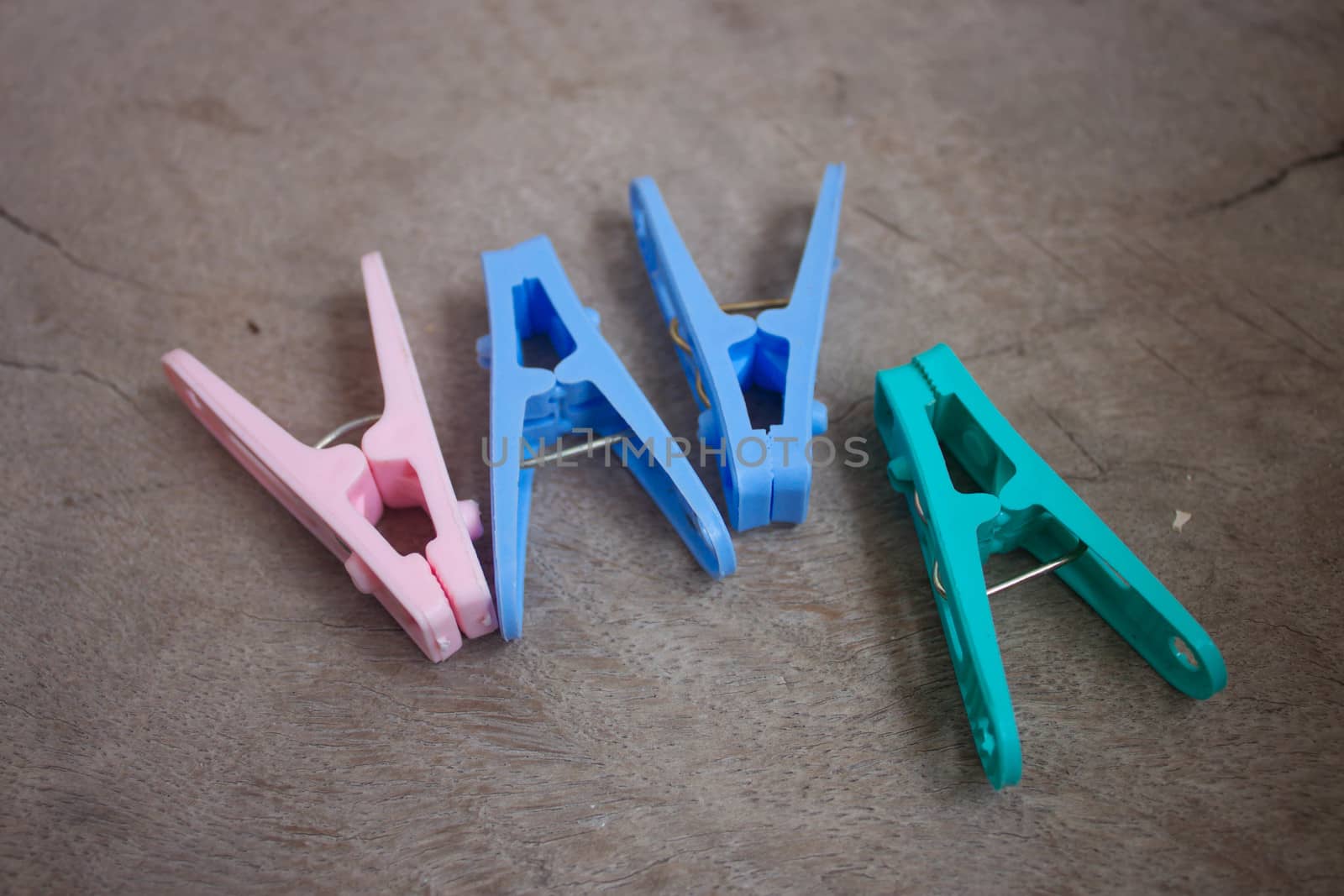 Closeup image of colorful clothespins on wood background