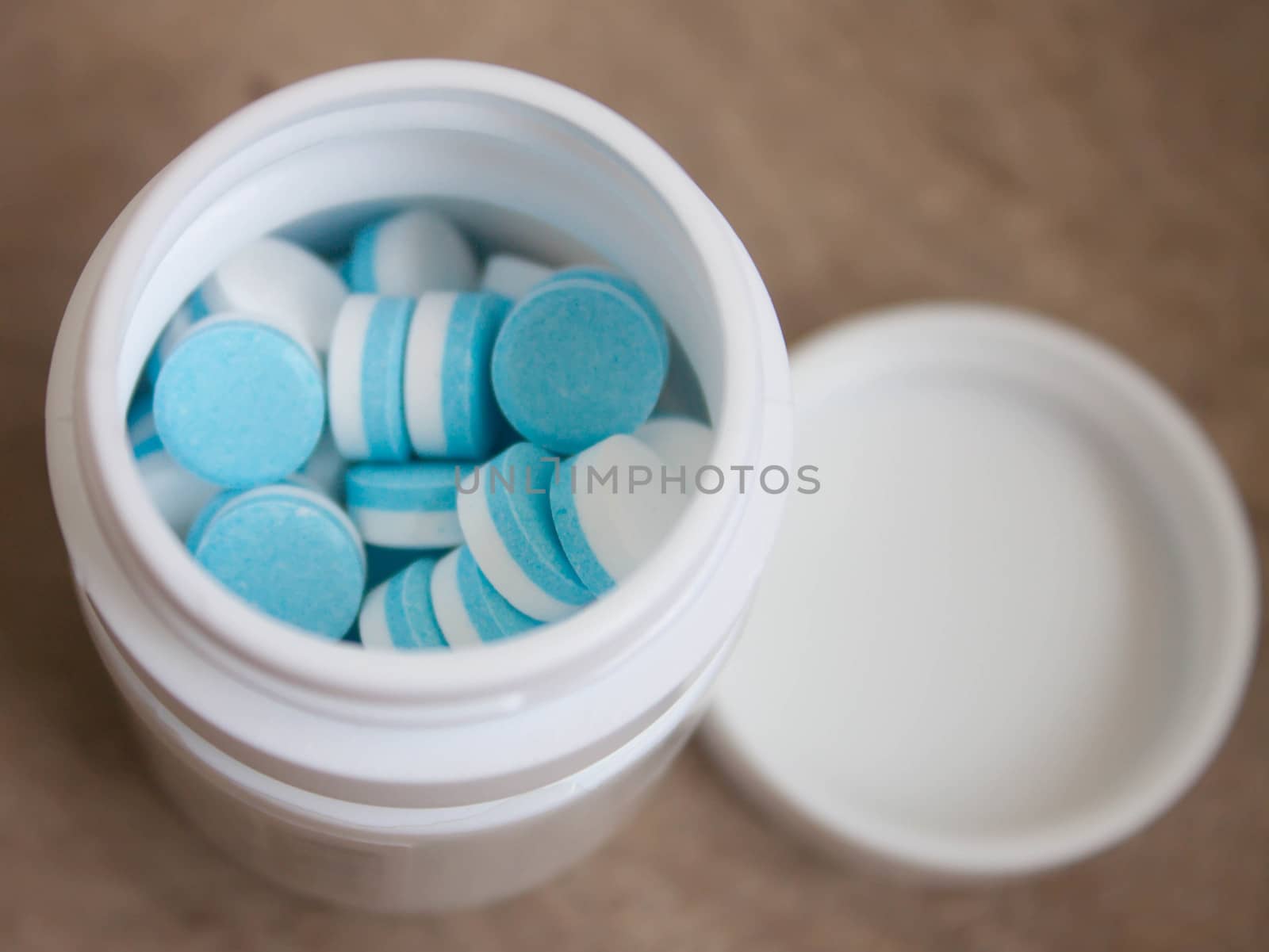 Paracetamol tablets, white and blue in the bottle cap.