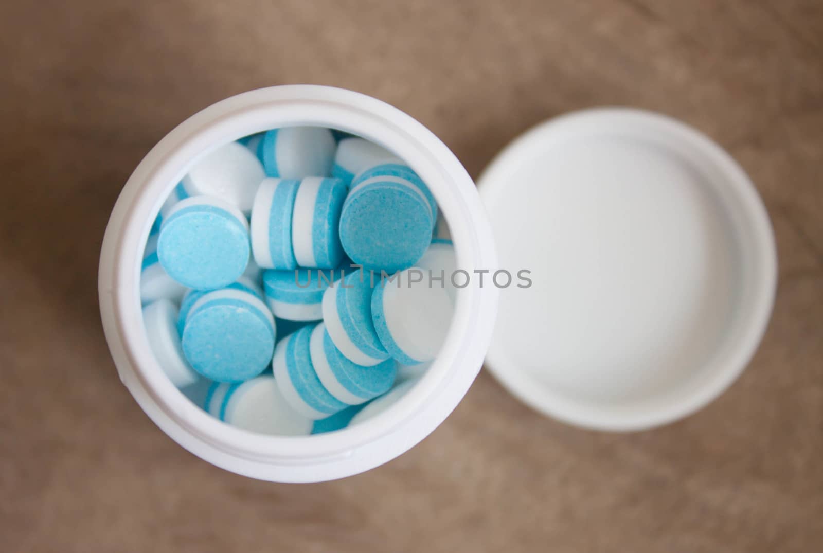 Paracetamol tablets, white and blue in the bottle cap.