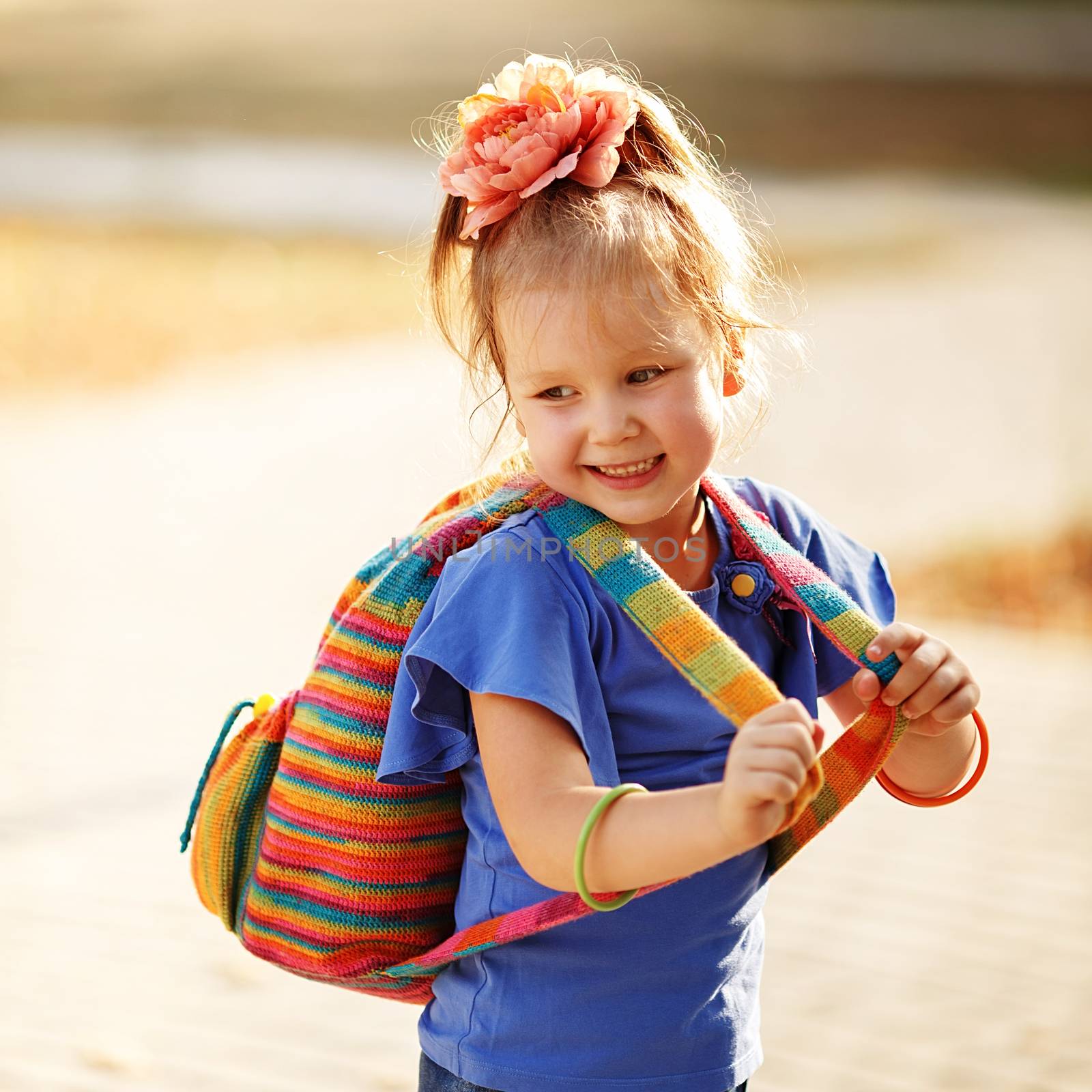 Portrait of an adorable preschool age girl with colorful knitted backpack. Preparation for school