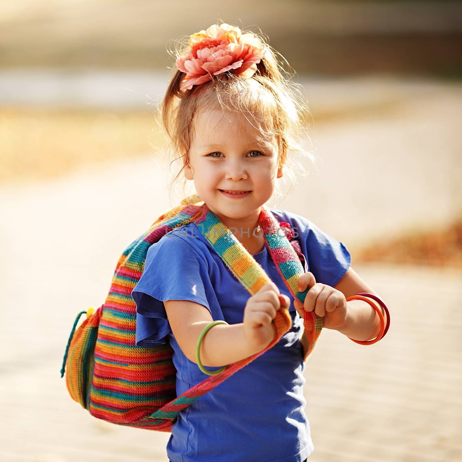 Portrait of an adorable preschool age girl with colorful knitted backpack. Preparation for school