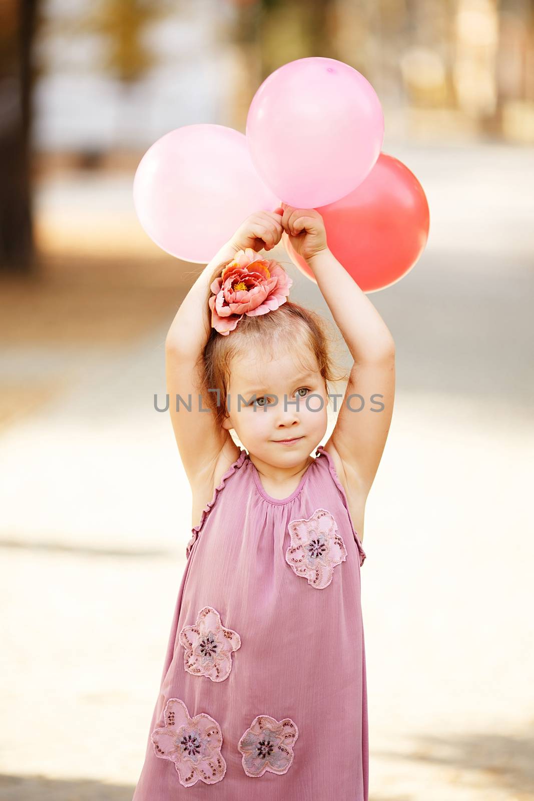 Portrait of laughing and playing little girl holding colorful ba by natazhekova