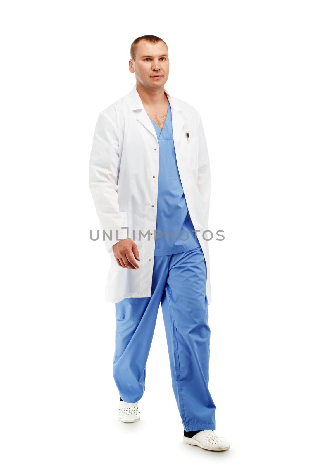 Full length portrait of a young male doctor in a medical surgical blue uniform in motion leaving the operating room against a white background