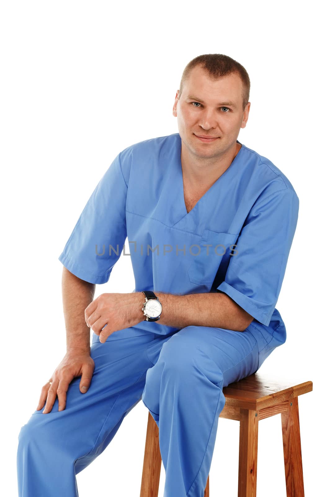 Portrait of a young male doctor in a medical surgical blue uniform against a white background