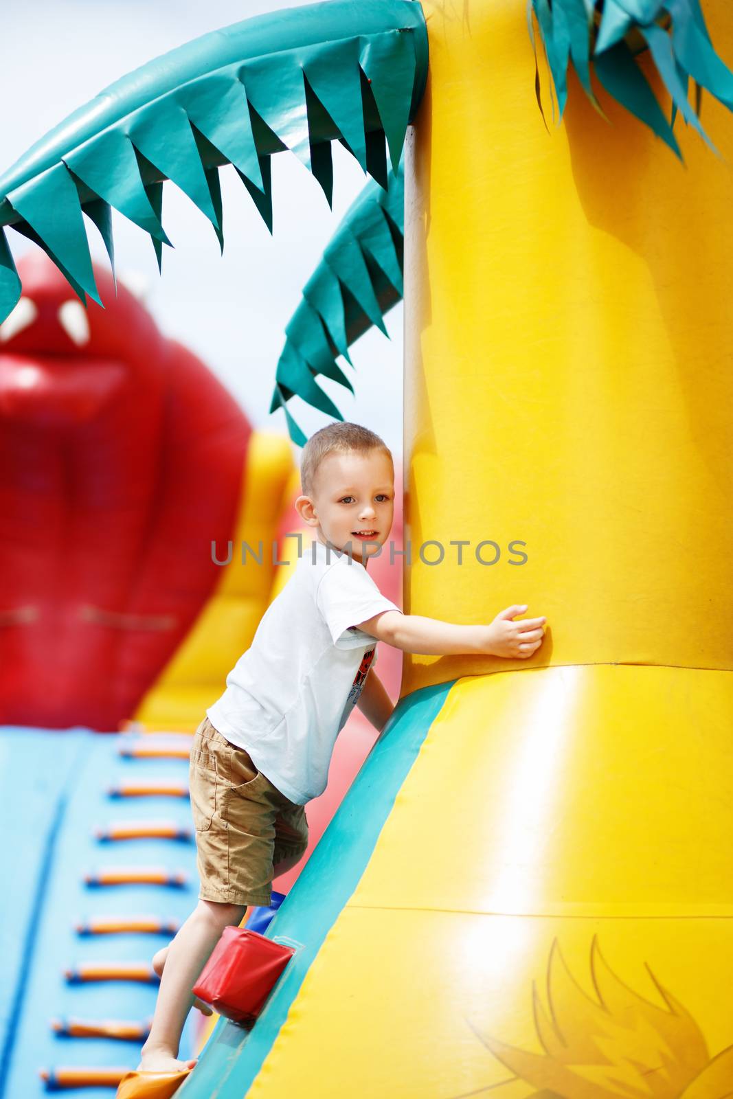 Little cool boy have fun and play on an inflatable trampoline