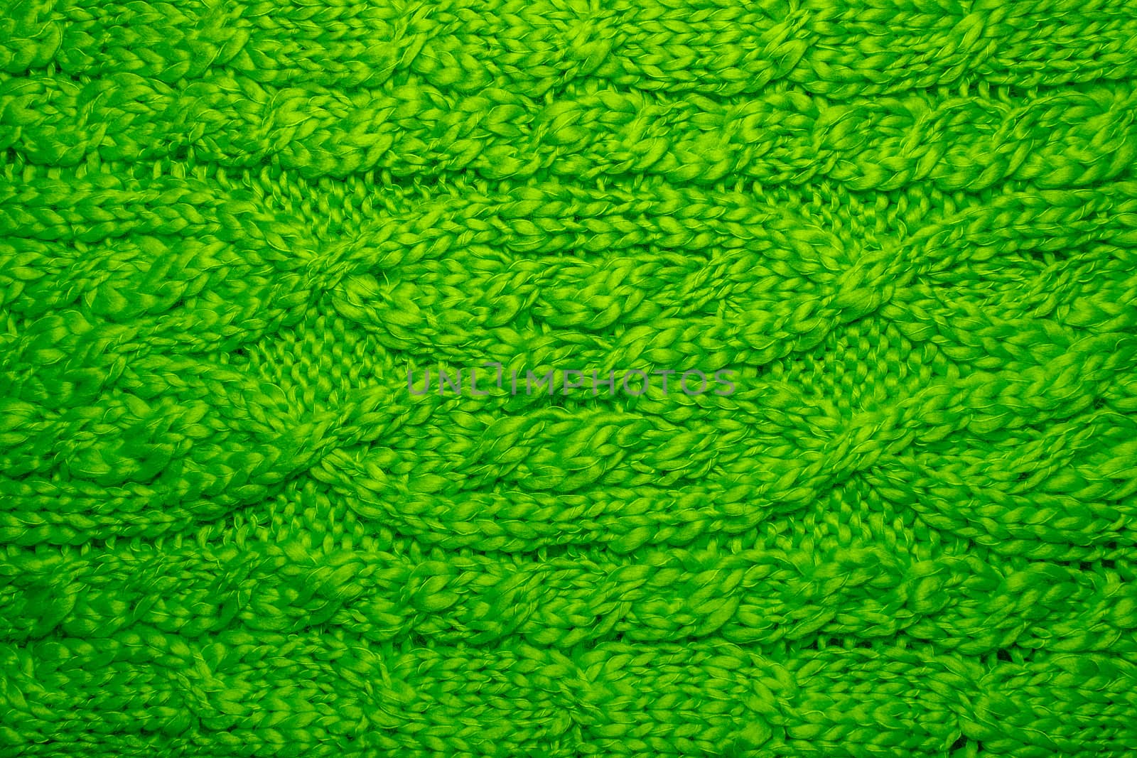 Wool sweater or scarf texture close up. Knitted jersey background with a relief pattern. Braids in machine knitting pattern. Wool hand-knitted or machine knitting pattern. Closeup Fabric Background