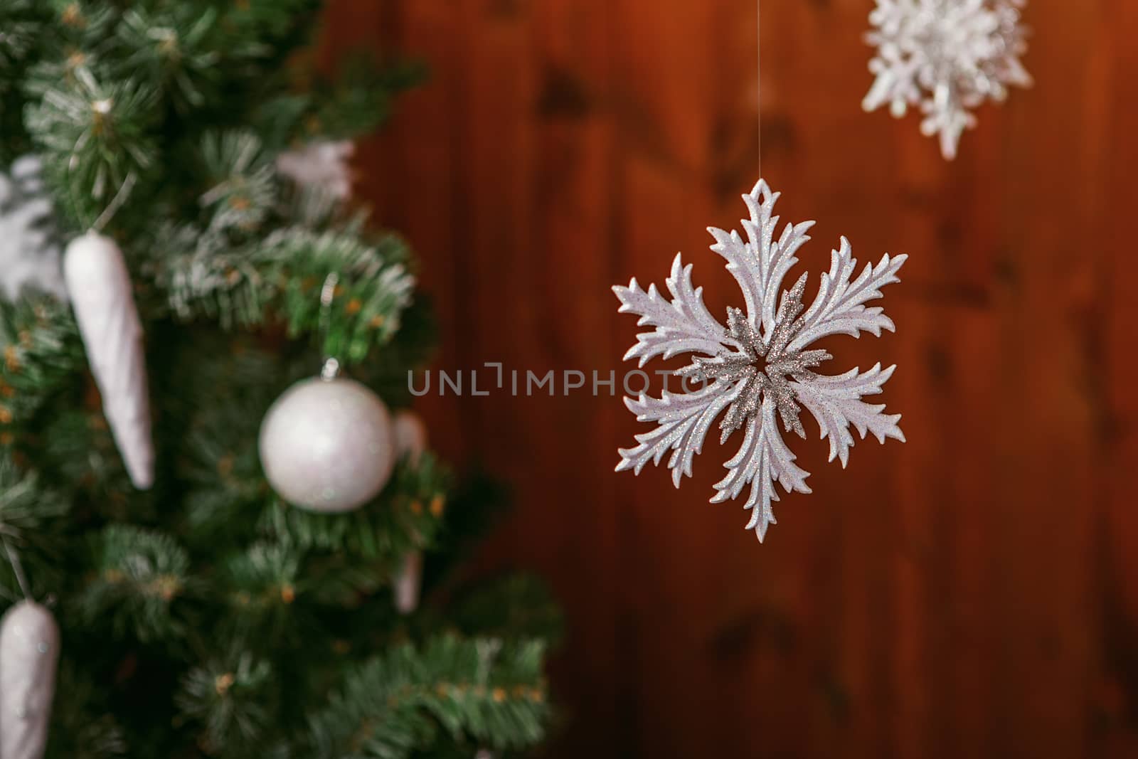 Traditional christmas or new year decorated tree with a white snowflake toy