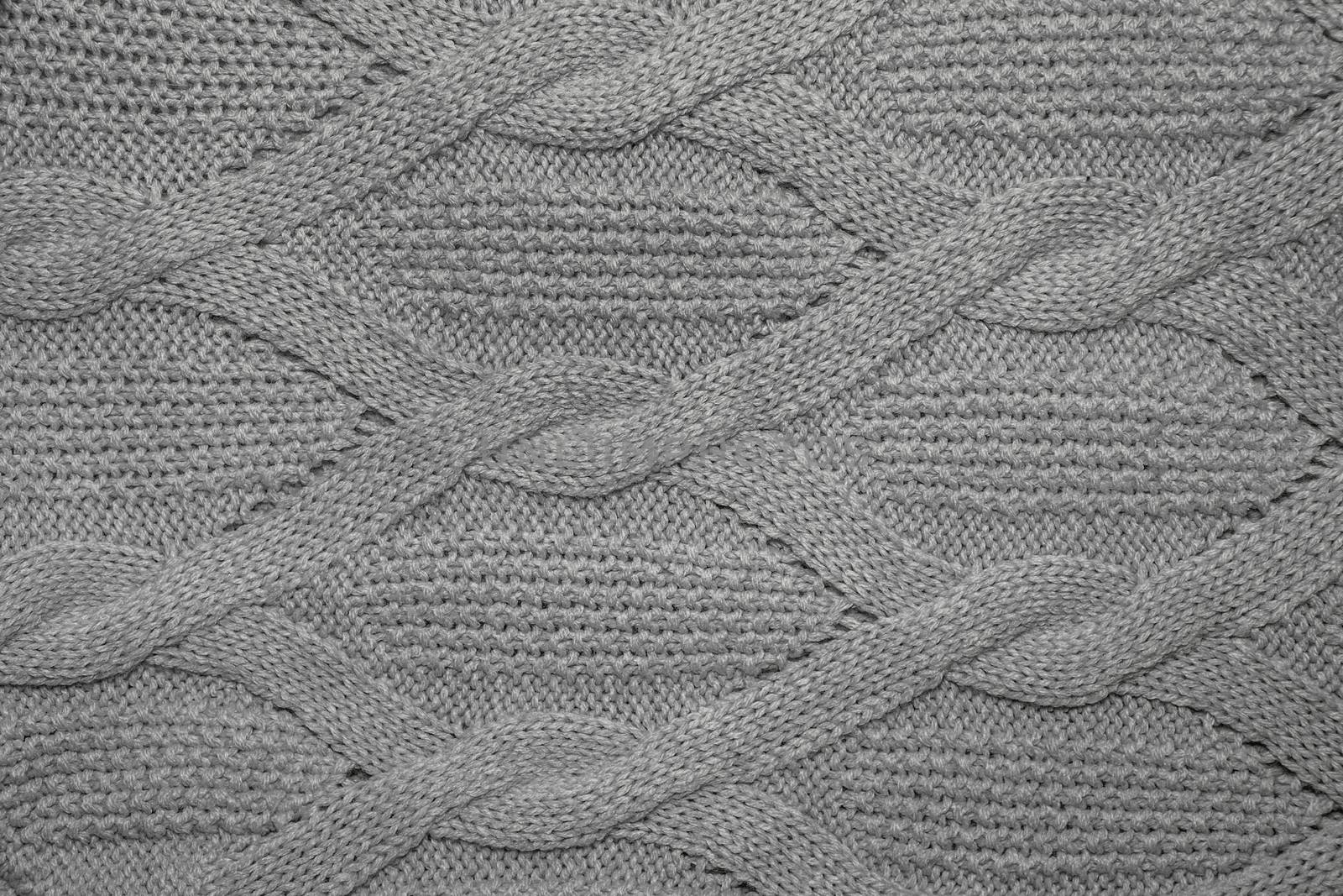 Gray wool sweater texture close up. Knitted jersey background with a relief pattern