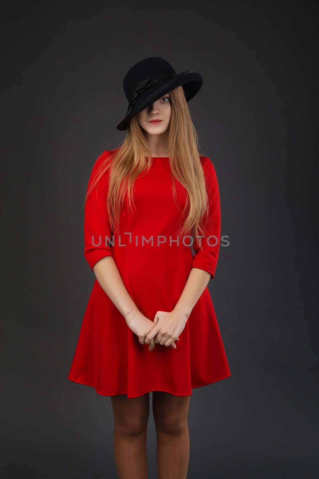A beautiful girl in red dress and black felt hat.