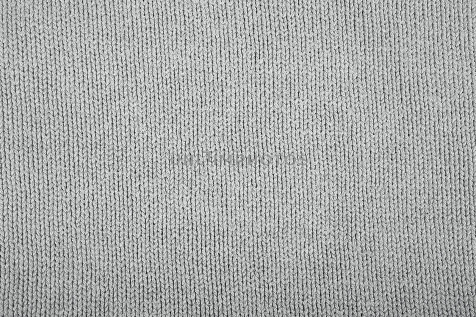 Wool sweater texture close up. Knitted jersey background with a relief pattern. Braids in machine knitting pattern