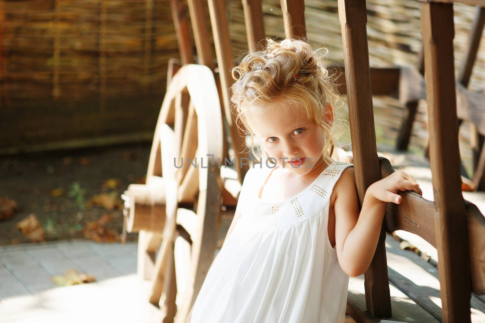 Portrait of an adorable preschool age girl with a hairdo with hairpins on her head. Positive emotions. Happy child.