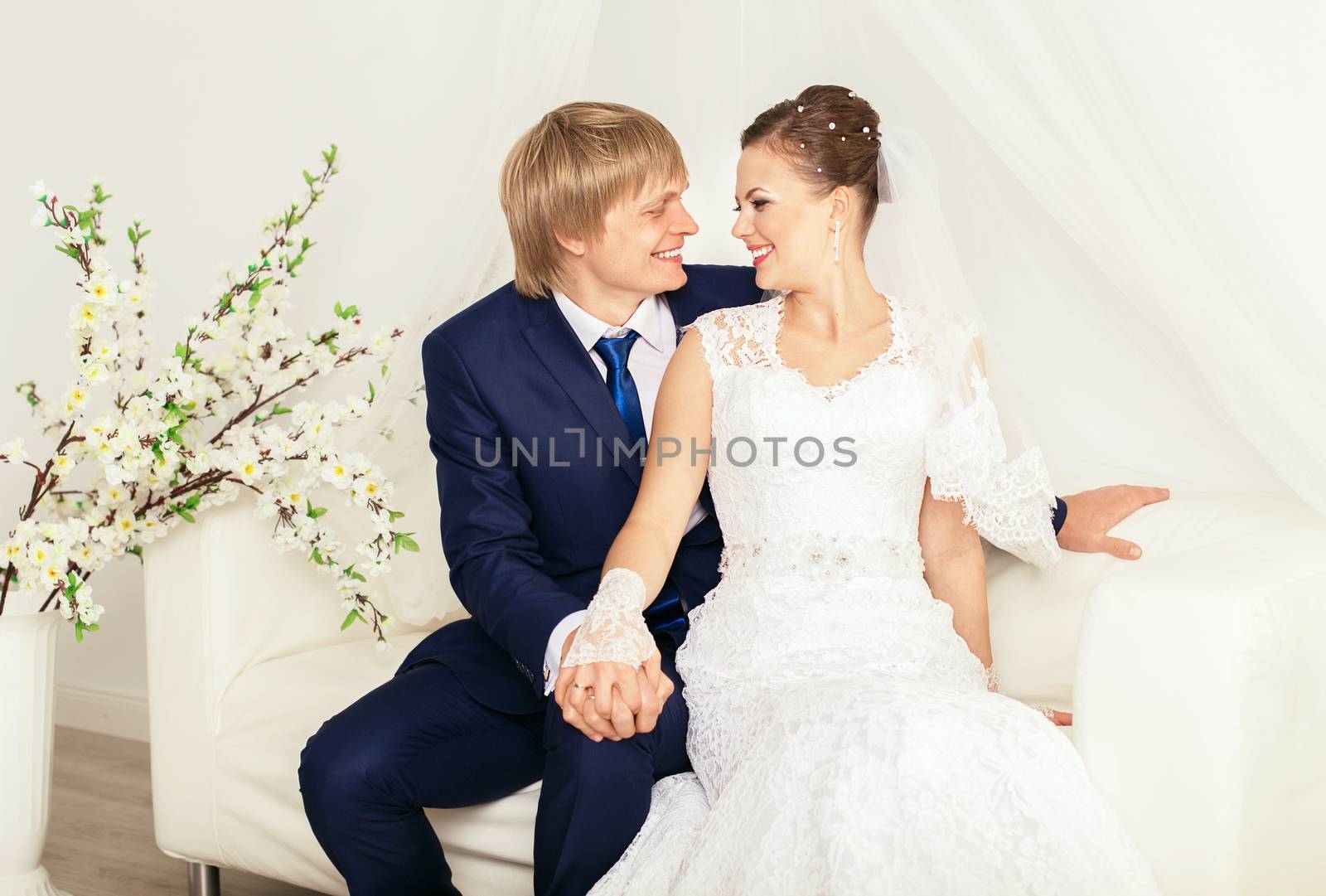 Laughing couple. Wedding photo shoot in the total white studio