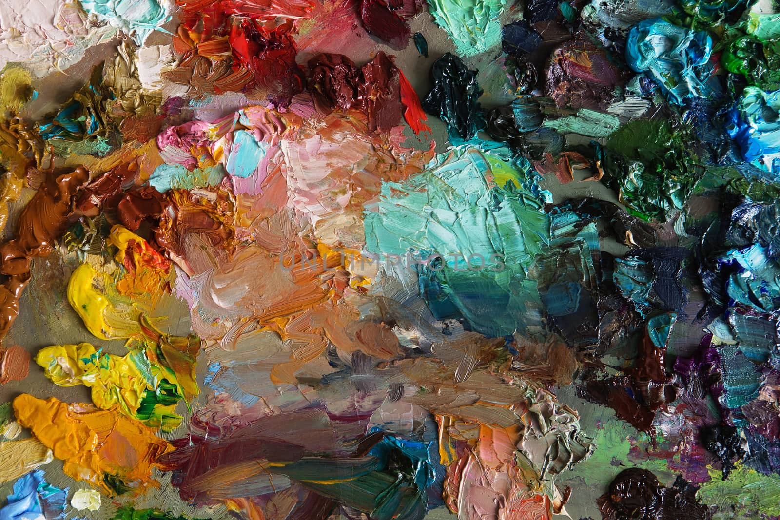 artists oil paints on wooden palette. macro artist's palette, texture mixed oil paints in different colors and saturation. art palette background