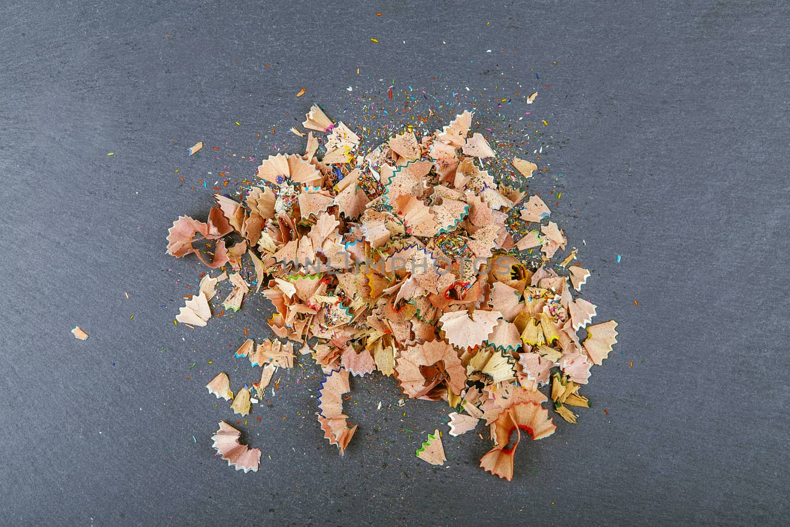 Background of multicolor pencil shavings. Close up colorful pencil shavings for background. Dynamic, abstract, horizontal composition of pencil sharpening shavings, close up, macro