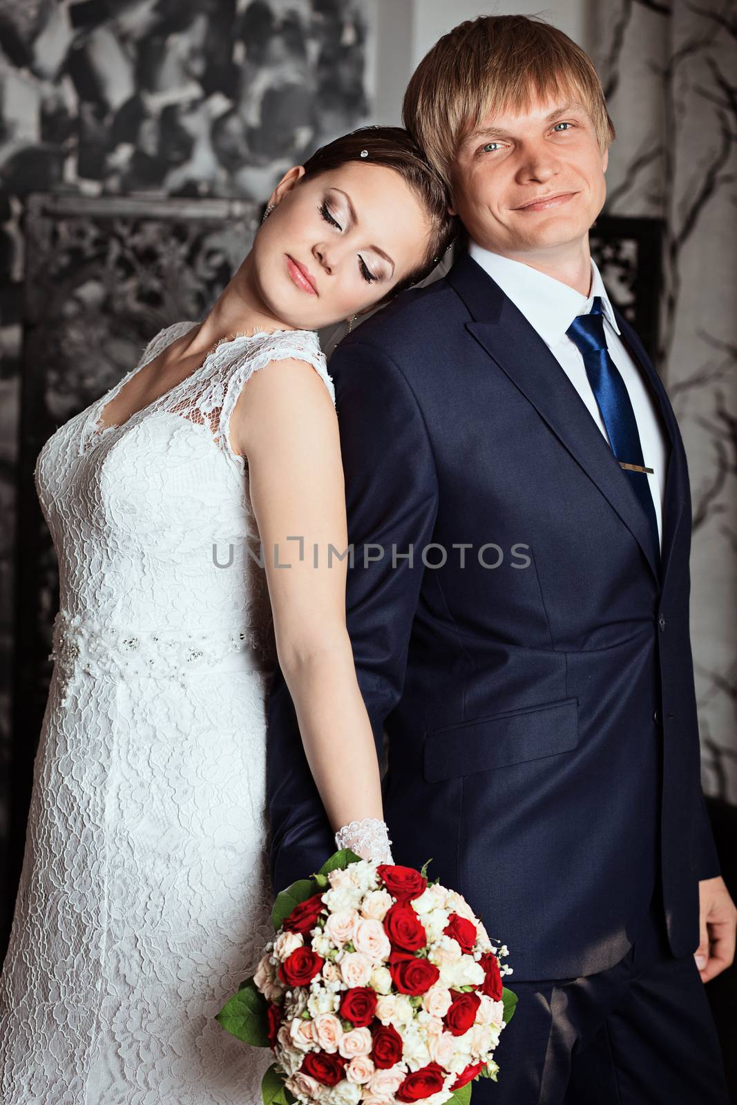 Bride and groom in studio with vintage interior. Photo of happy newlyweds. Beautiful fashion bridal couple