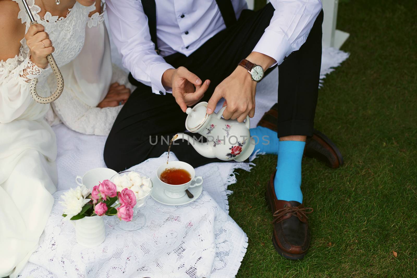 Bride and groom in bright clothes on the green grass by natazhekova