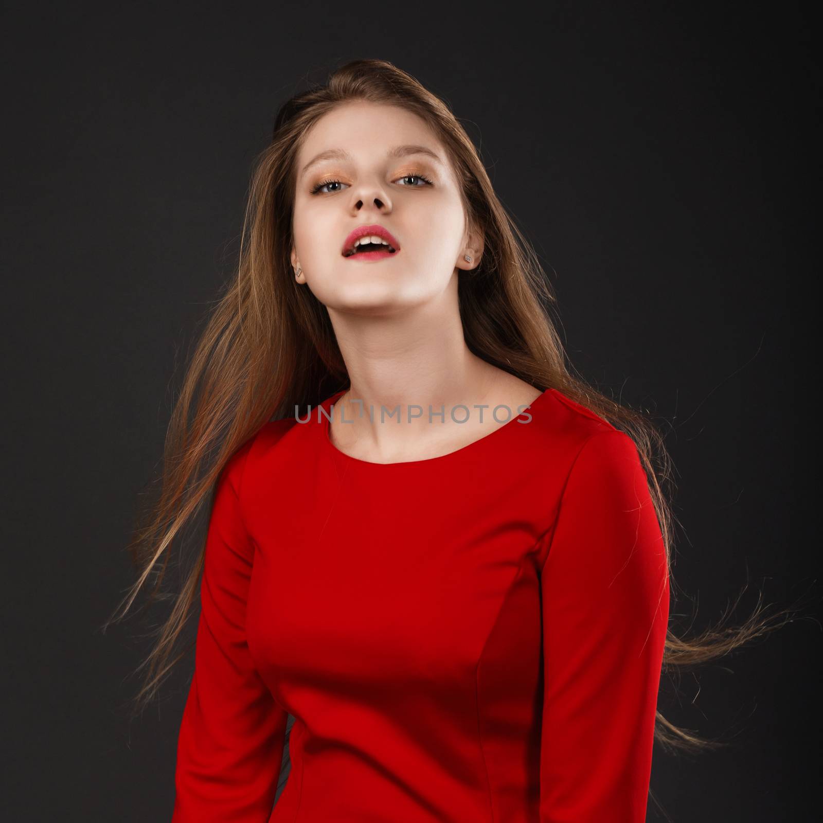 Portrait of a young beautiful girl with eyes closed in a red dre by natazhekova