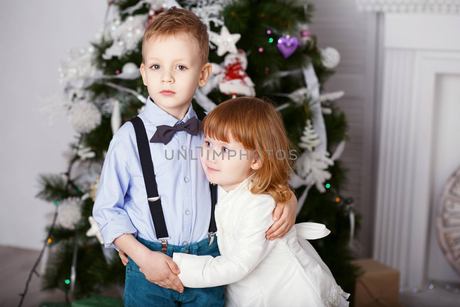Portrait of a happy children - boy and girl. Little kids in Christmas decorations. Brother and sister hugging.