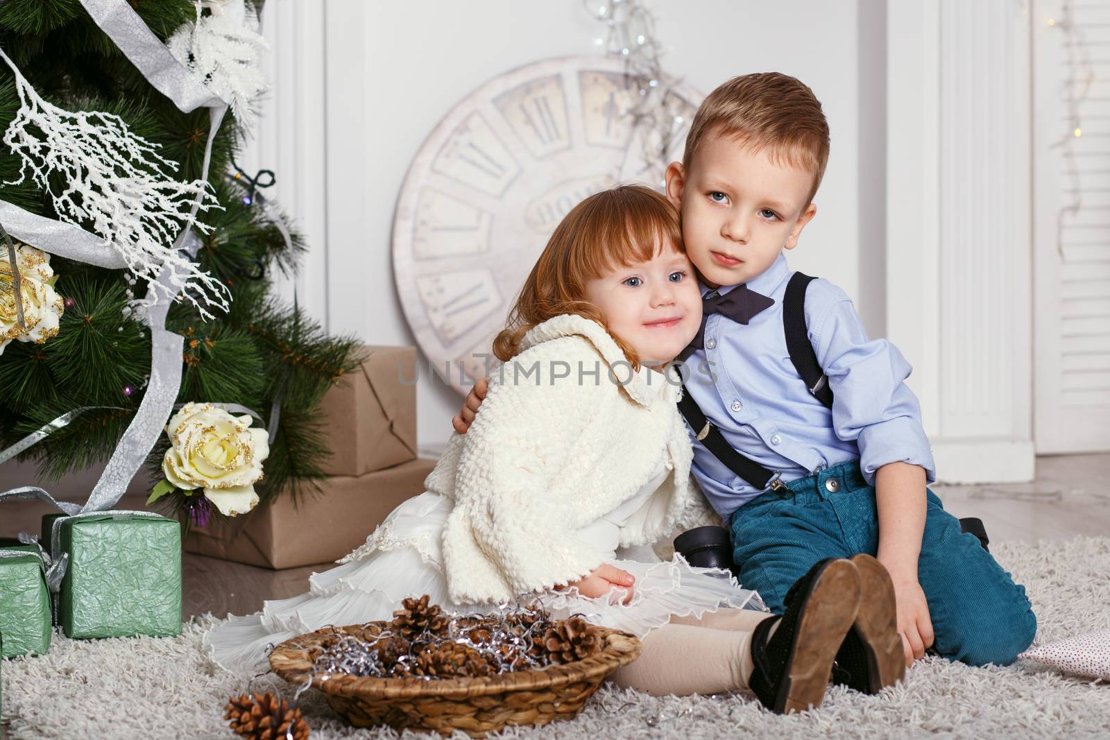 Portrait of a happy children - boy and girl. Little kids in Christmas decorations. Brother and sister hugging.