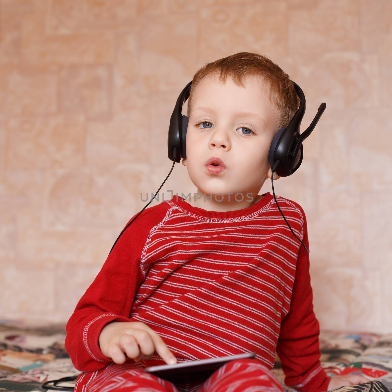 Little boy with headphones listening to music and singing