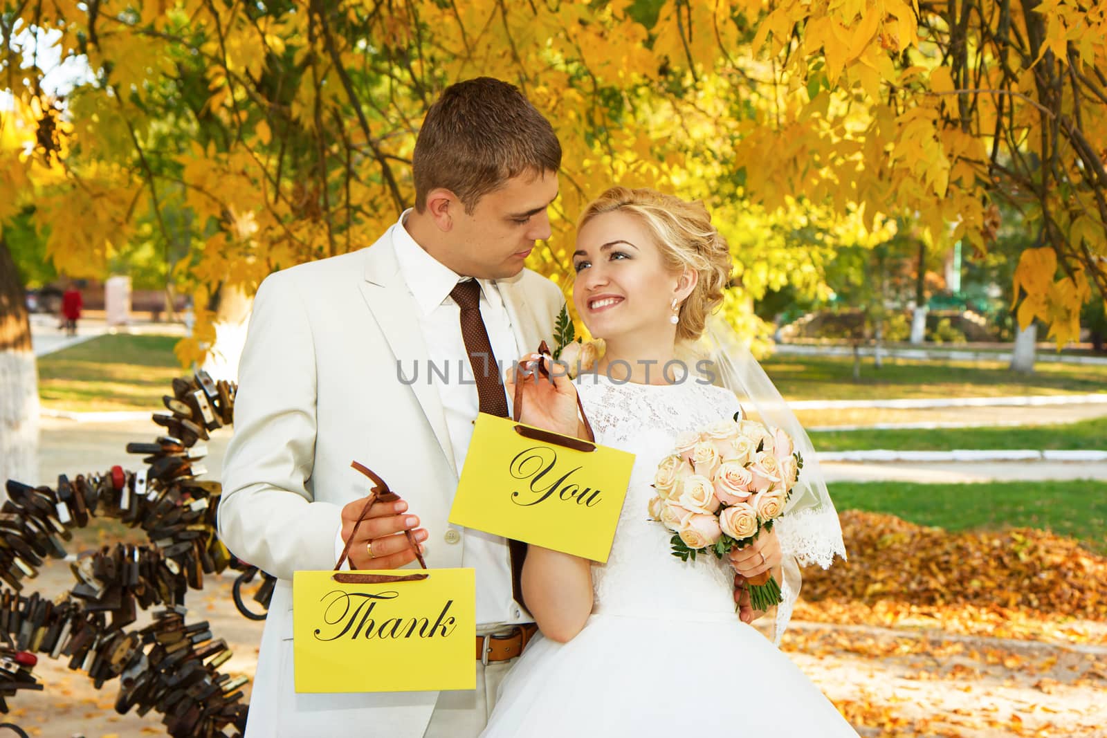 Beautiful young bride and groom in love. Couple with signs with the words "Thank" and "You". Thank You