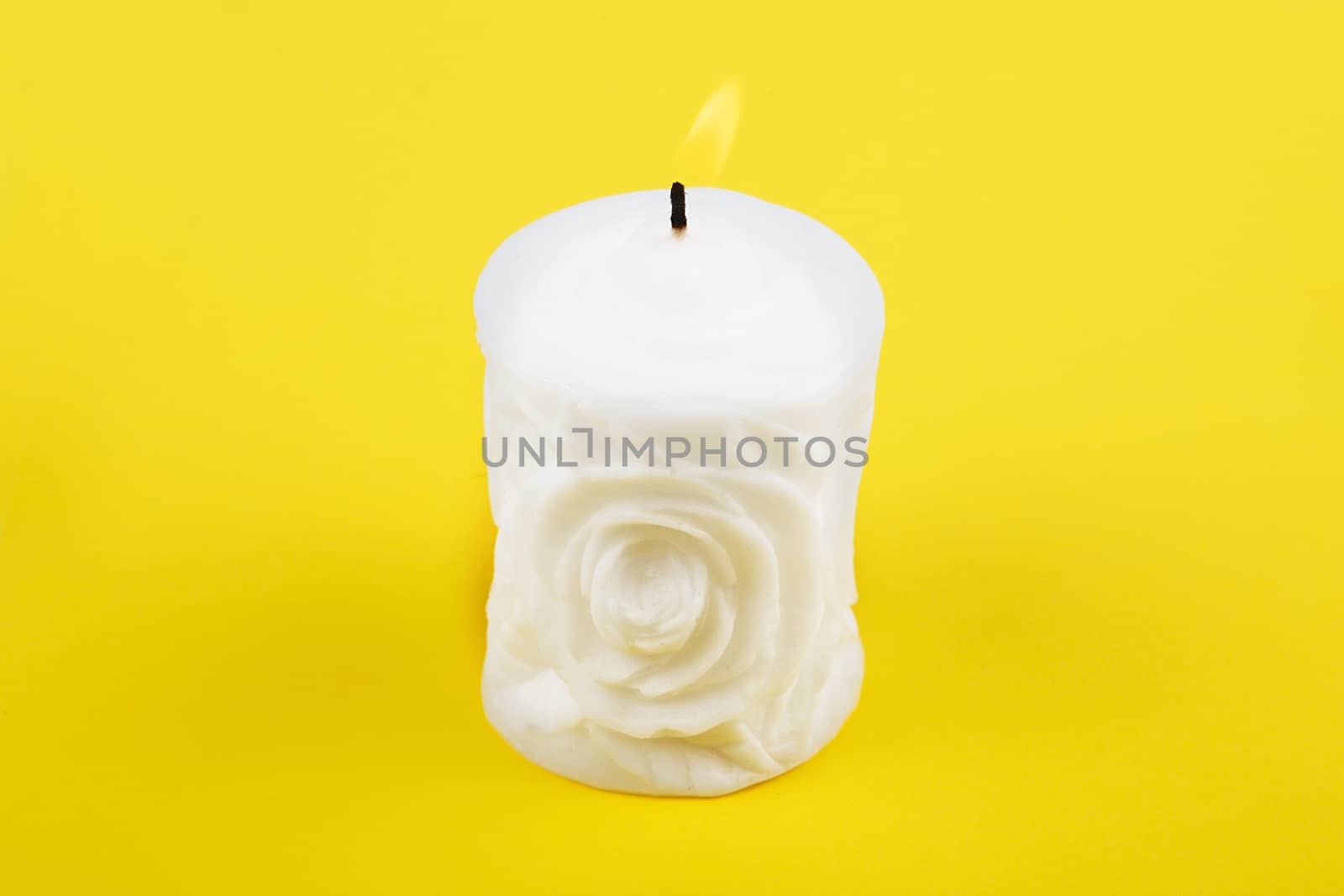 Carved white candle on yellow background by natazhekova