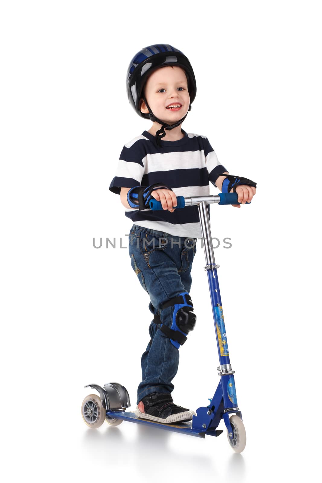 Little boy in protection helmet and in the knee and arm ruffles riding his scooter isolated on white background
