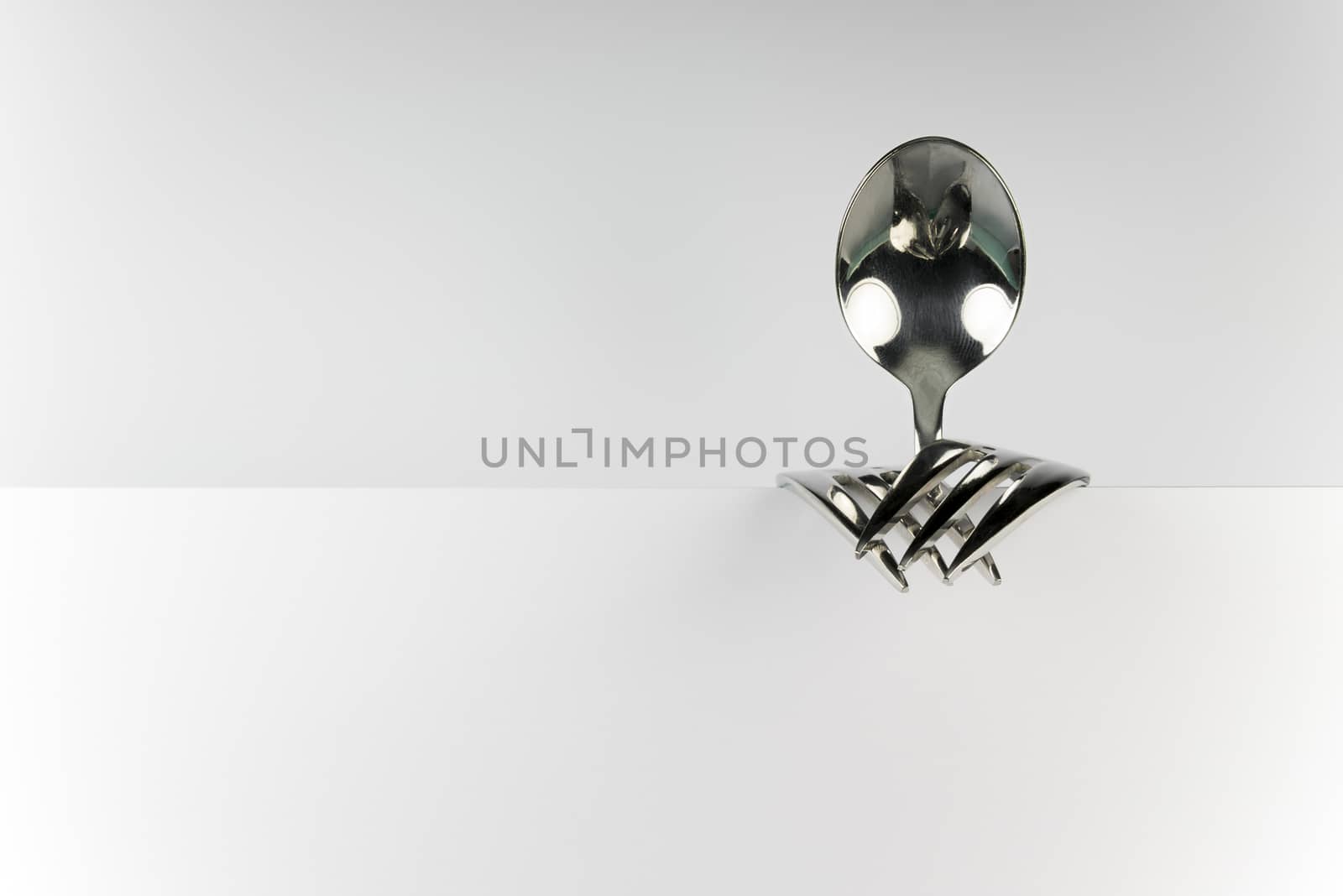 Metal spoon and two forks formed into conceptual fantasy figure
