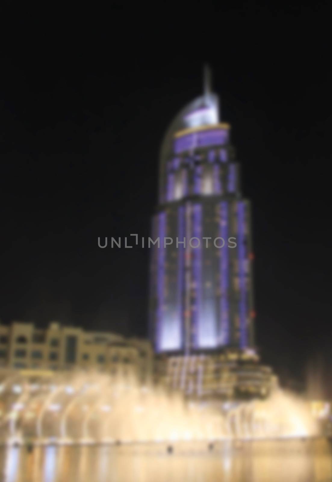Dubai promenade singing fountains on the background of architecture, sunset April 7, 2014 is   blurred