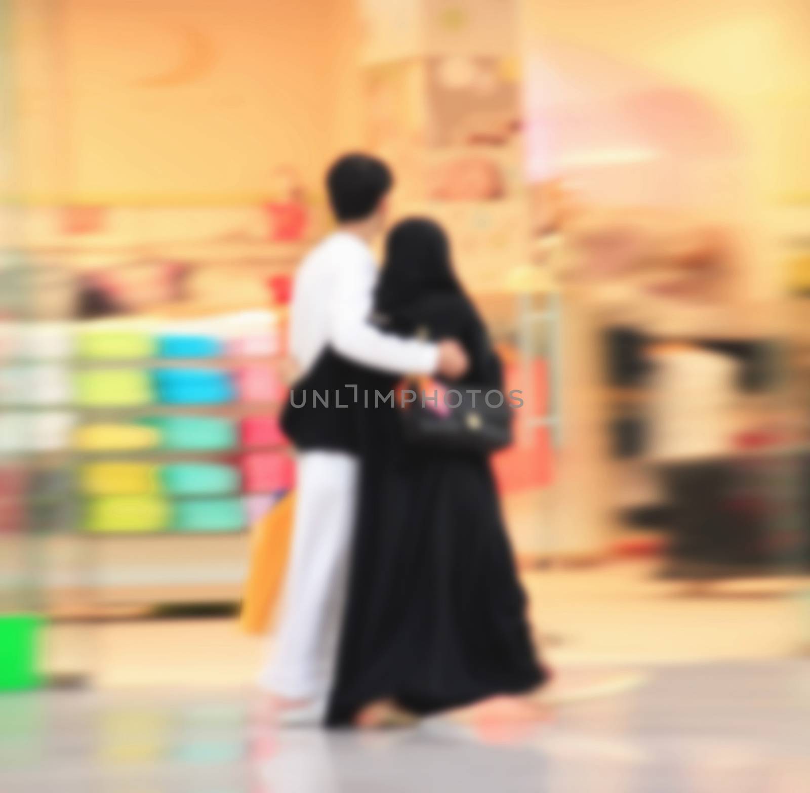 Arab sheikhs men and their wives and families in a mall make a purchase, Dubai, people go to the mall, market, blurred for background