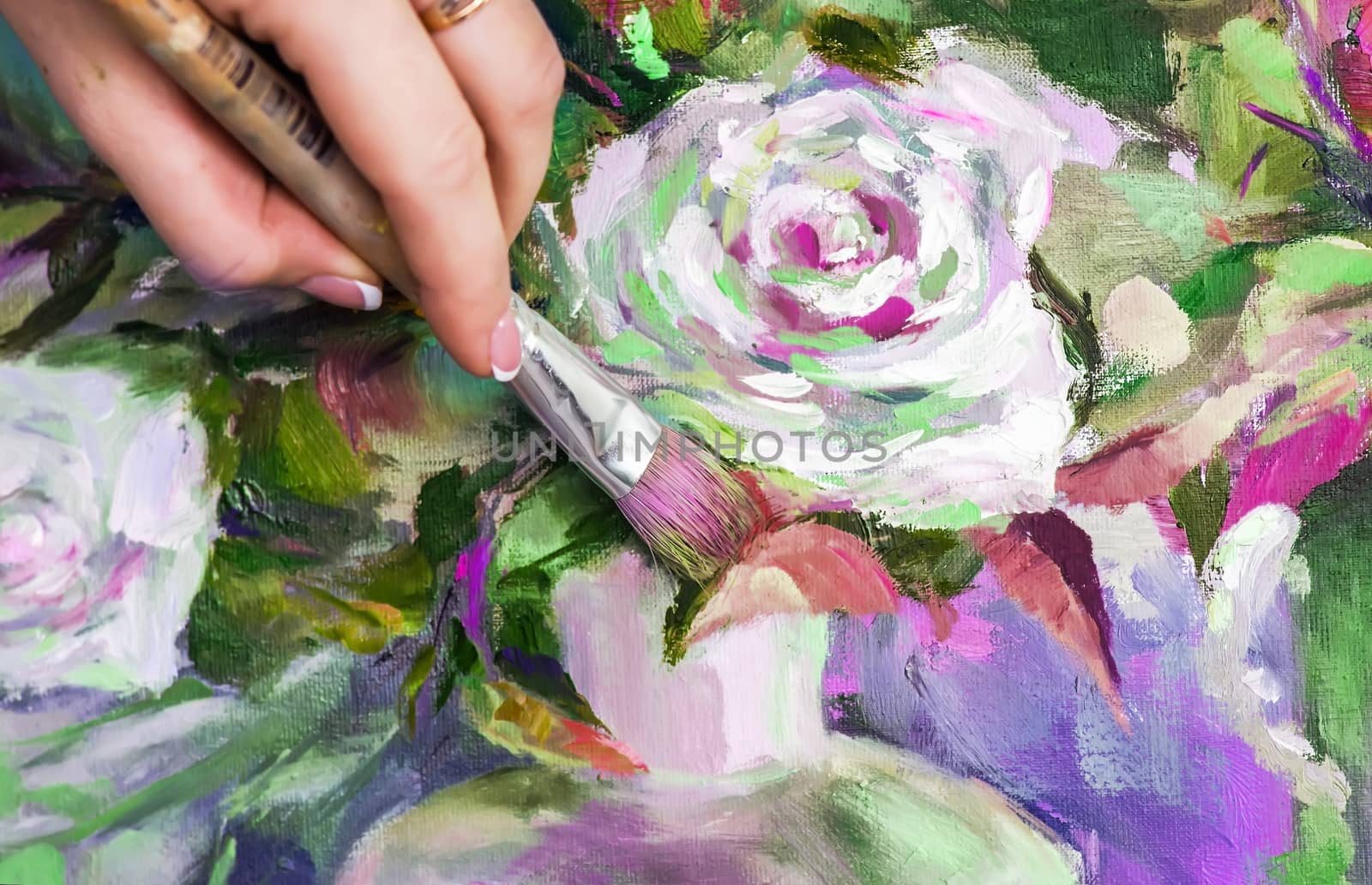 Brush and oil paints on a palette, paint a picture of the artist's hands, texture mix paint in different colors. Artist holding a palette with paint, brushes and palette knife