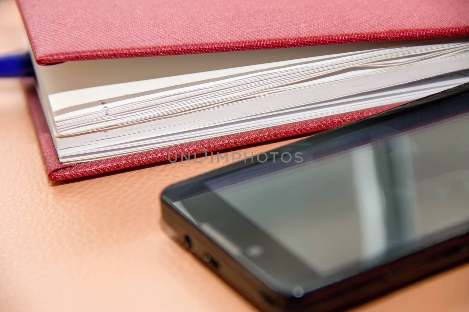 notebook, diary and mobile phone, pen and smartphone and laptop on the table, the business concept, business records and addresses, tasks, and phone calls, defocused
