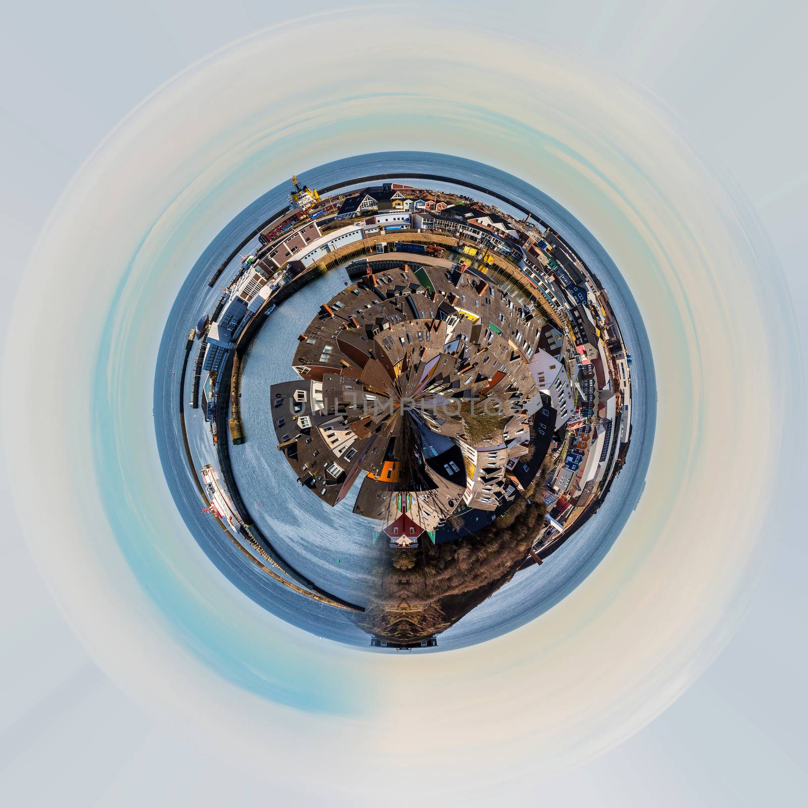 Planet of colored Crab fisher hutches at harbor Island Helgoland, Germany, nordic style houses with boat and blue sky, Little planet city concept. Tiny planet projection