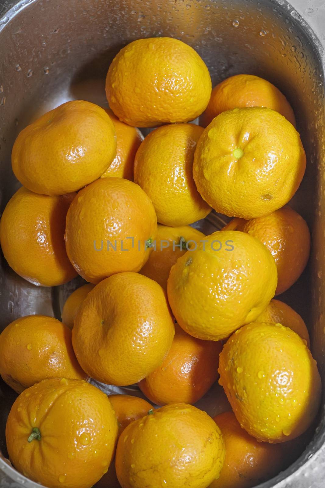 tangerines washed, Wash fresh mandarins in retro colander by KoliadzynskaIryna