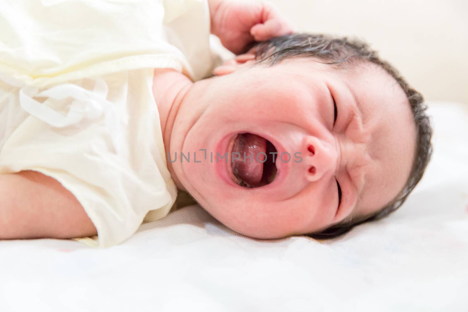 newborn baby crying in her bed