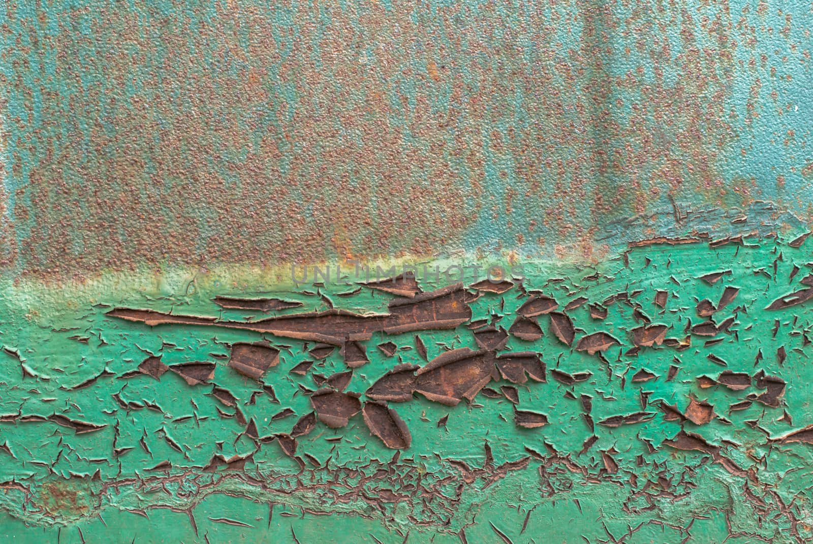 fragment of a rusty iron surface covered with old paint, which has long been under the influence of different climatic conditions