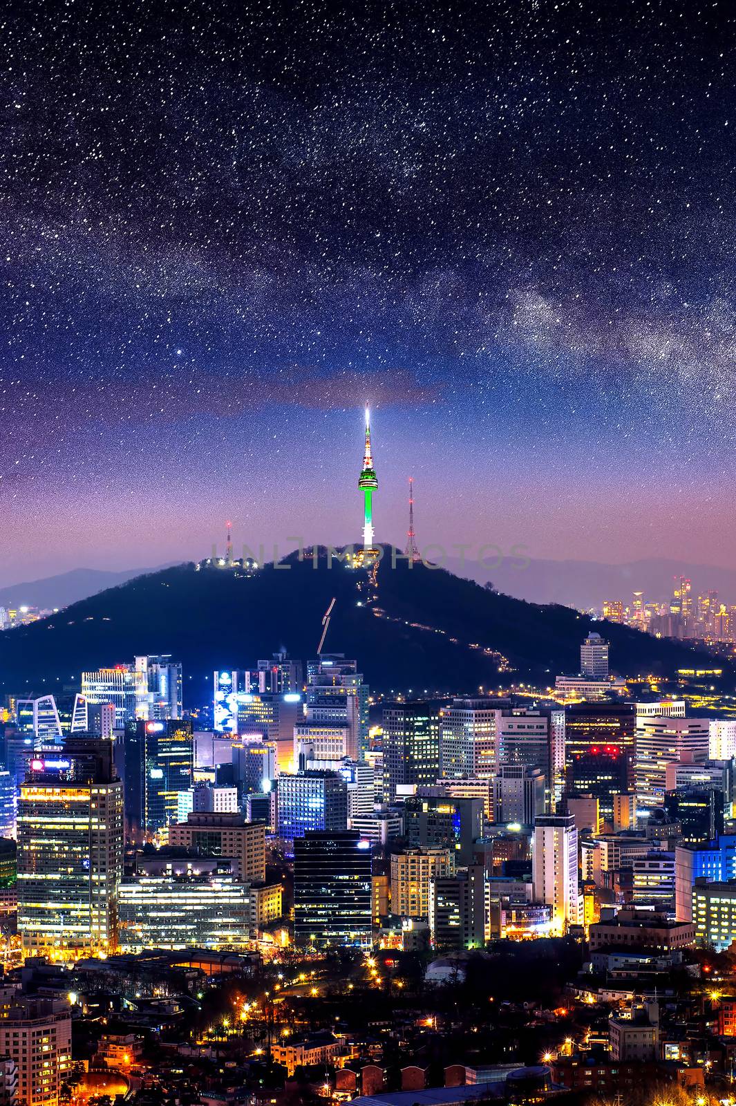 View of downtown cityscape and Seoul tower with Milky way in Seoul, South Korea.