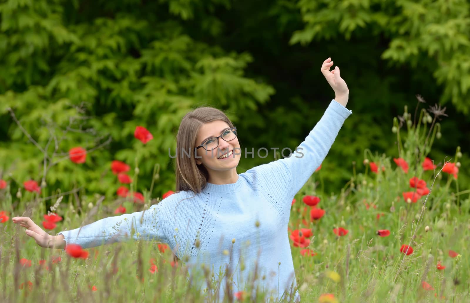 Young girl playing in a poppy field