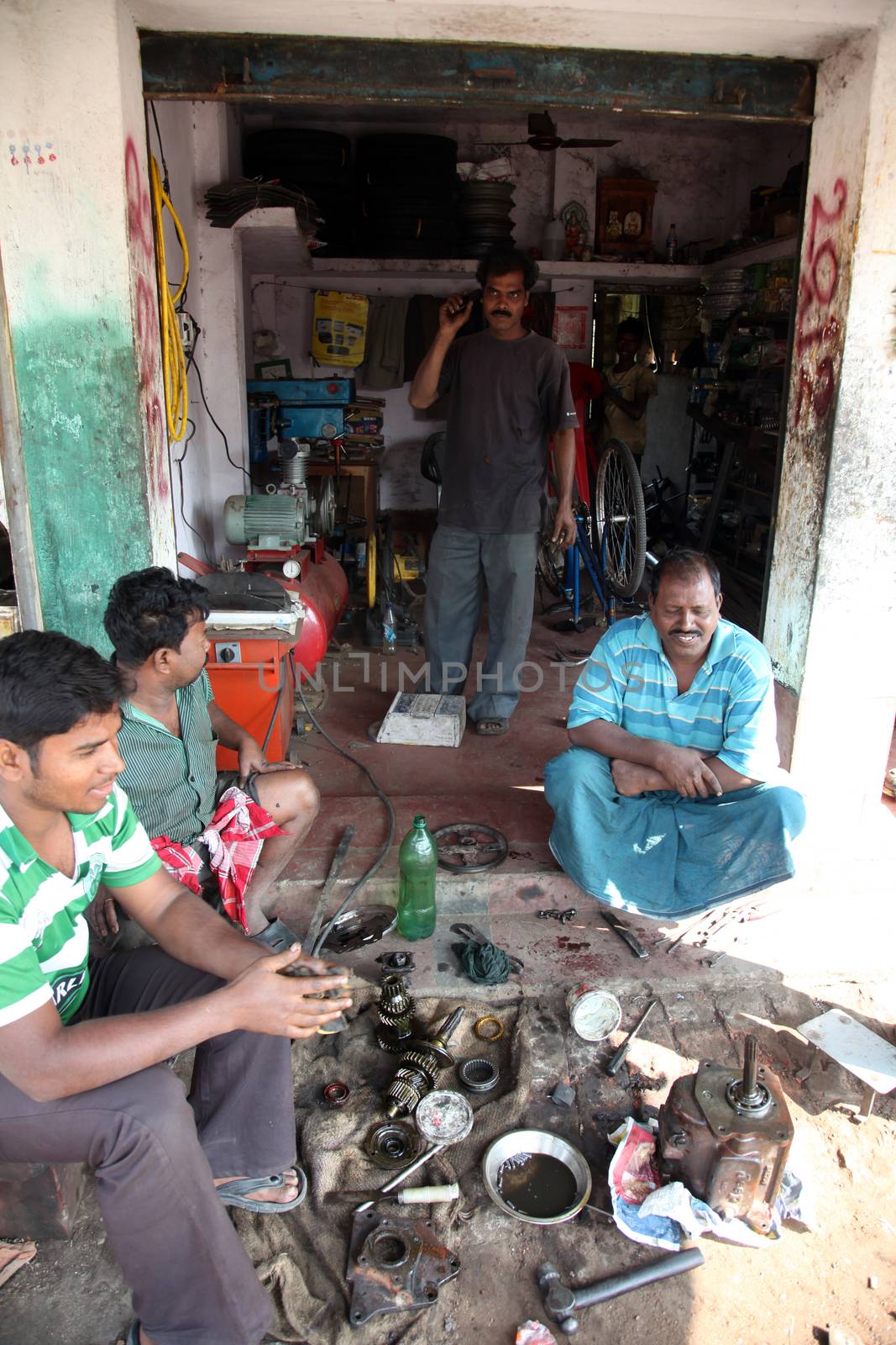 Motorbike repair service center is in working process in old building. Bikes is the common individual transport in India