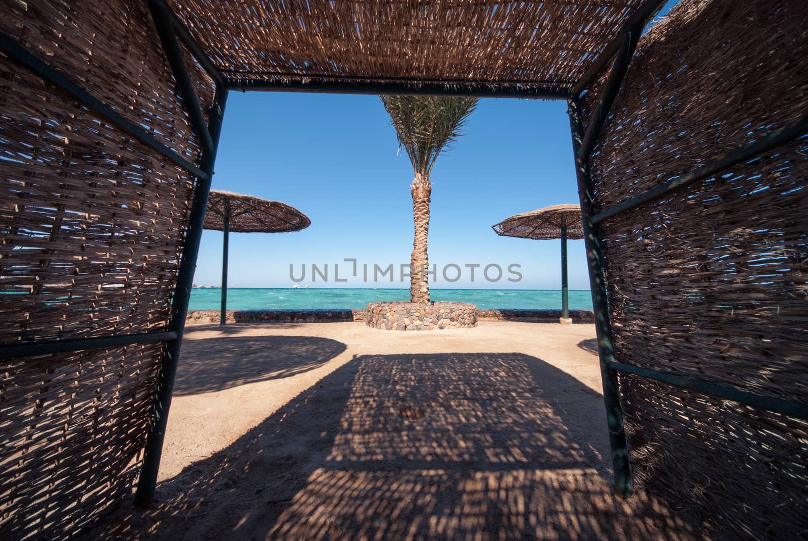 wicker sunshade shelter hovel on the beach in ocean sea resort. Vacation summer time by skrotov