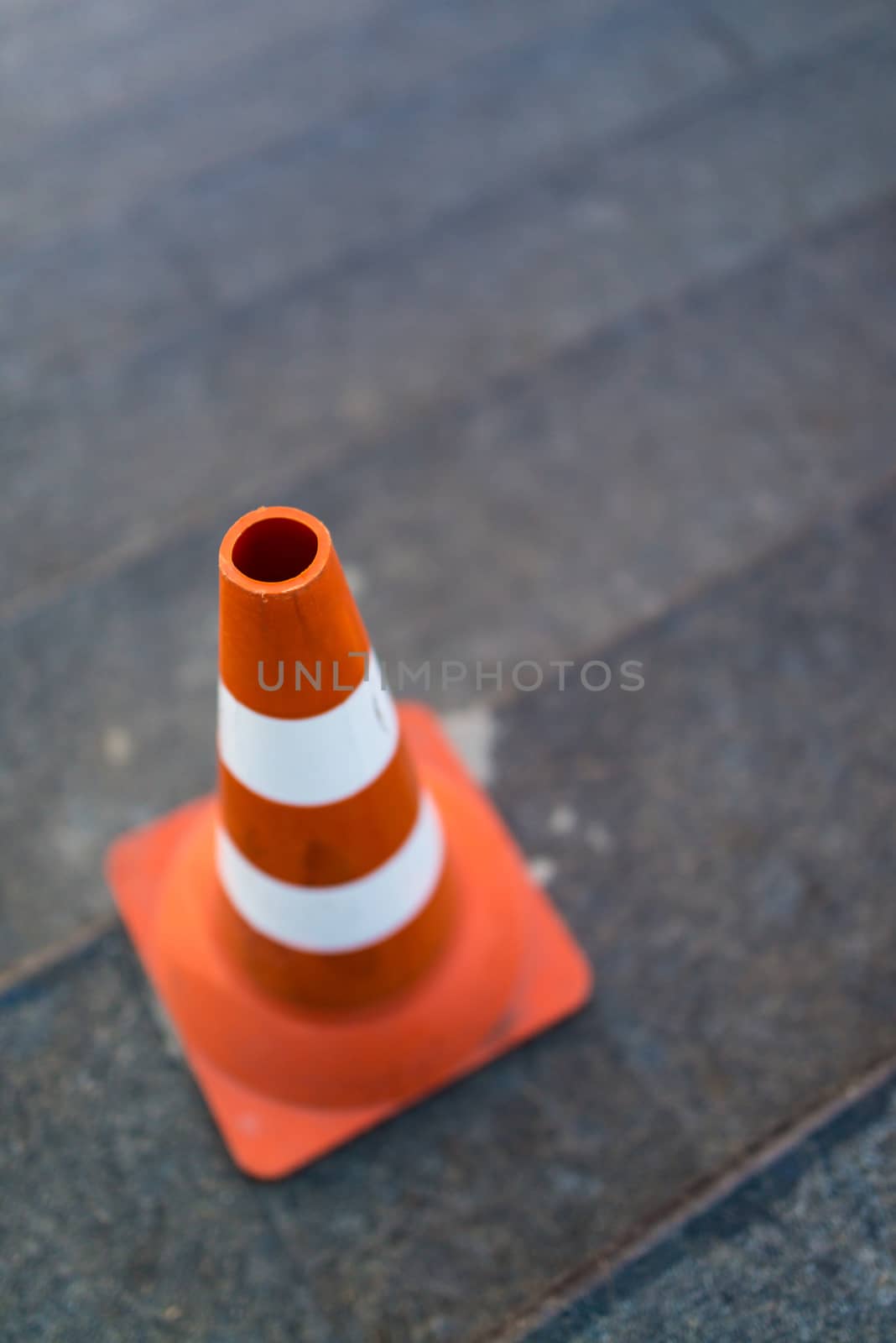 traffic cone, with white and orange stripes on gray staircace copy space.