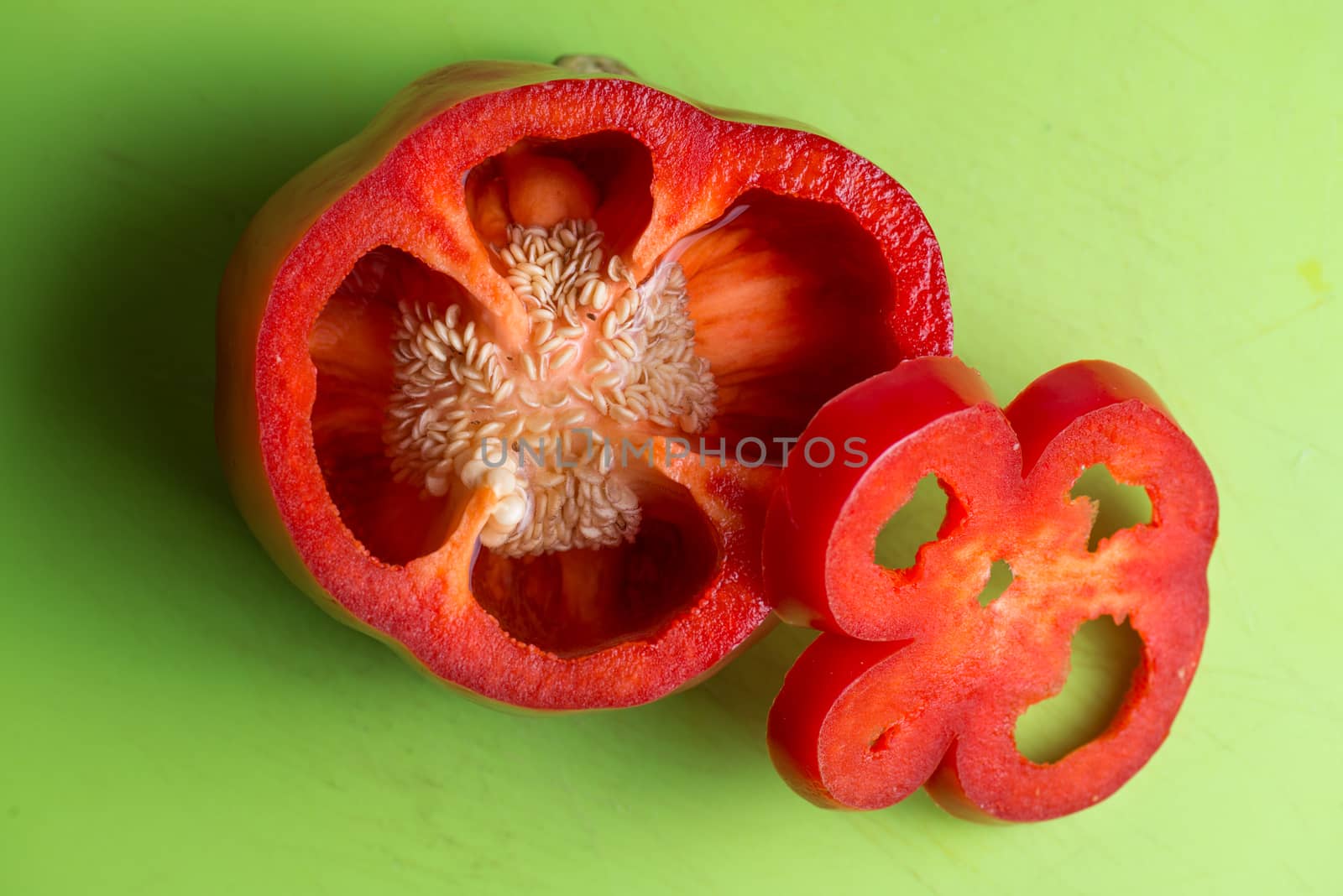 isolated red Pepper on green background. Sliced and fresh. by skrotov