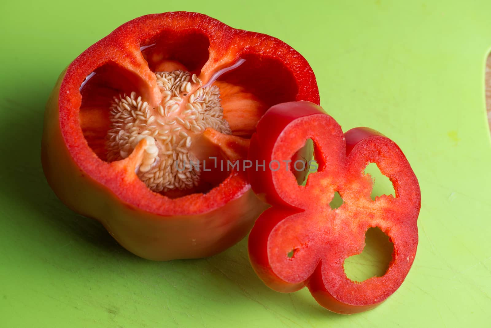 isolated red Pepper on green background. Sliced and fresh. by skrotov