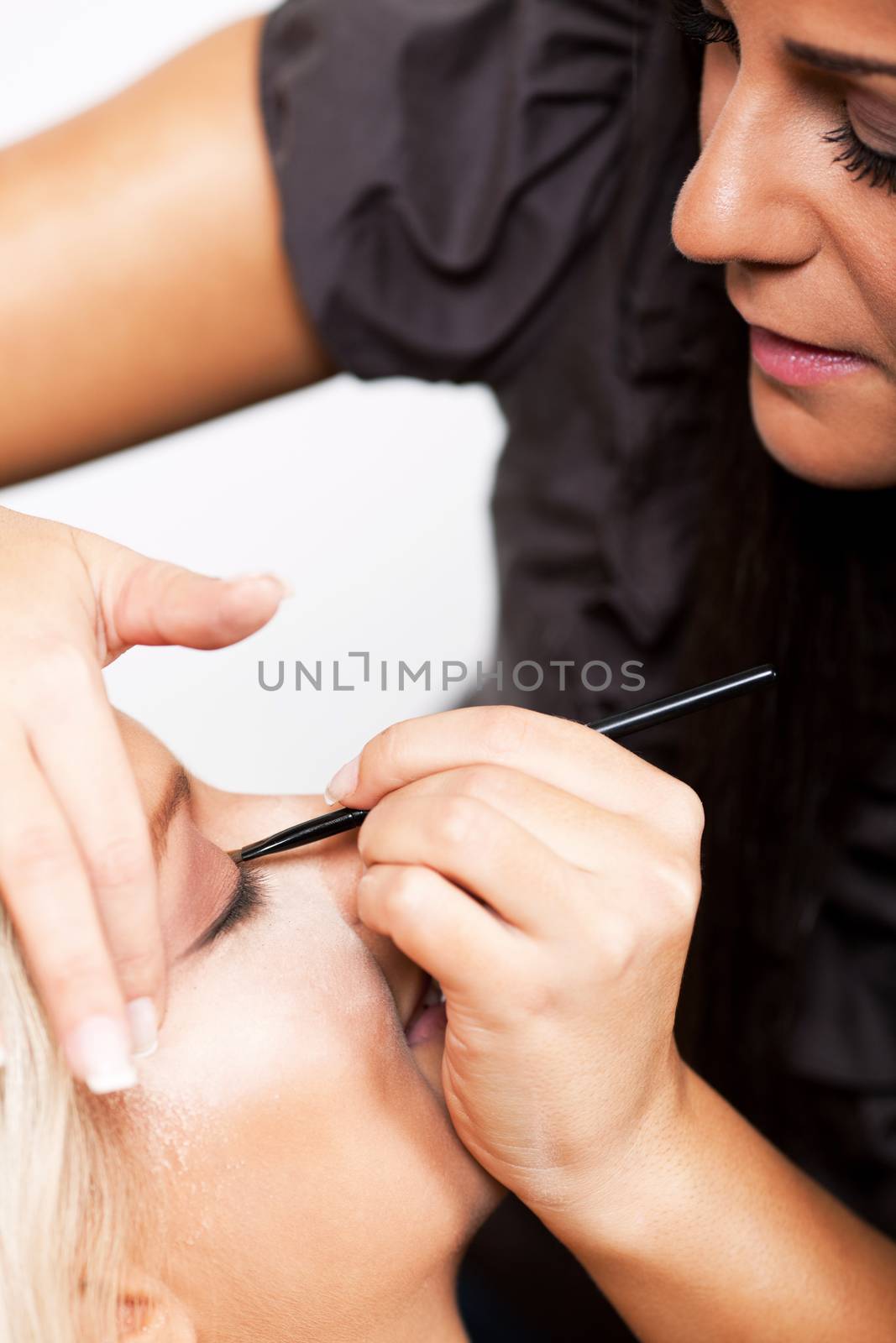 Make-up artist applying makeup on beautiful woman