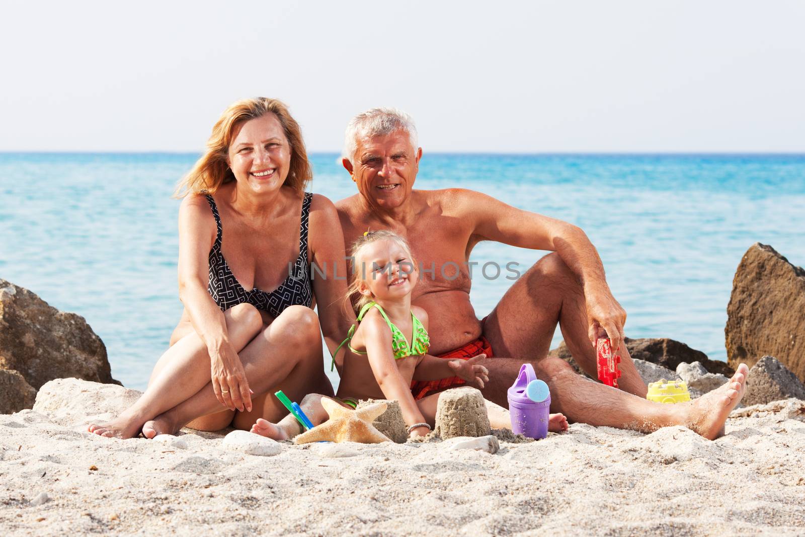 Little girl with grandparents on the beach by MilanMarkovic78