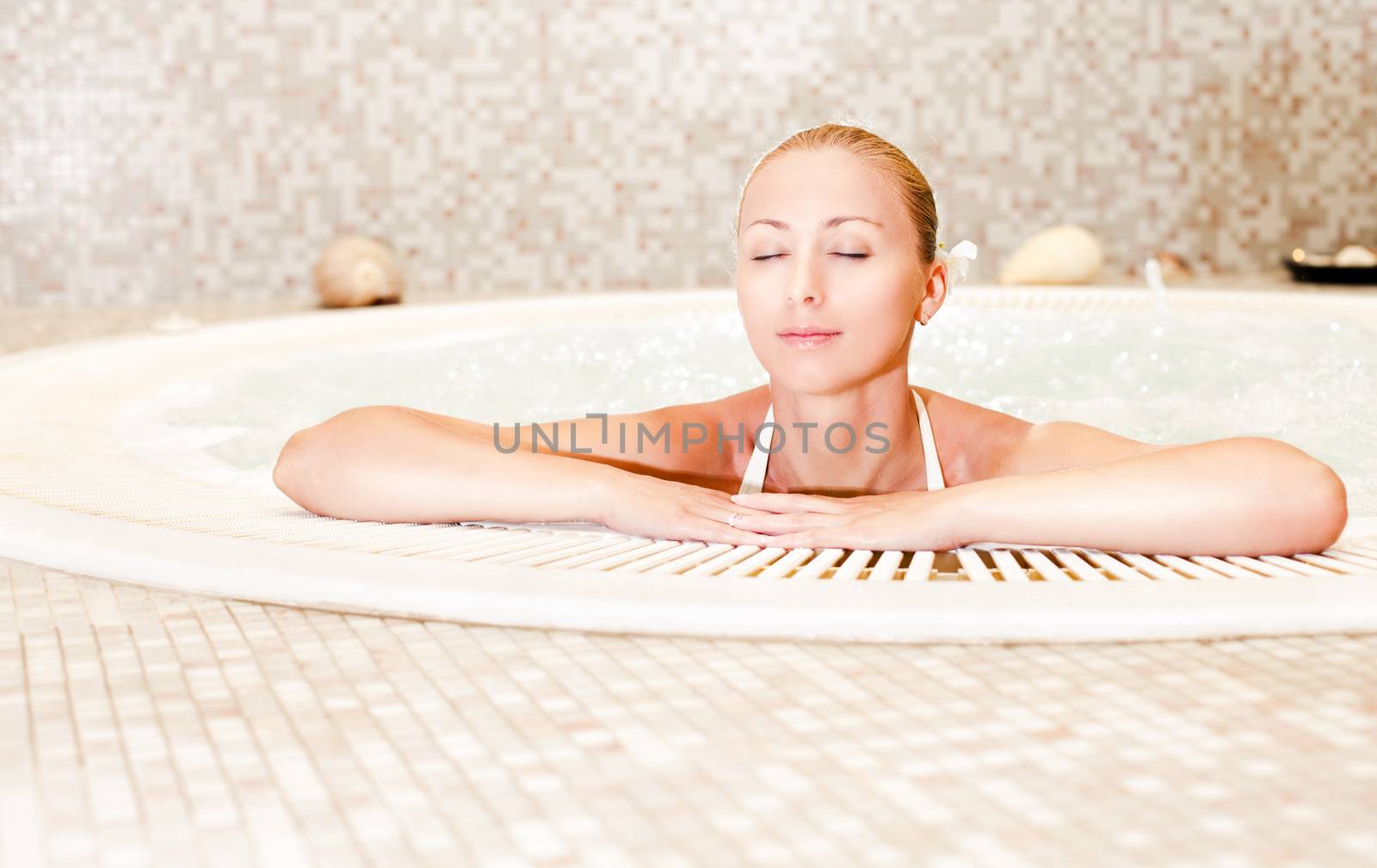 Young beautiful woman relaxing in the Jacuzzi
