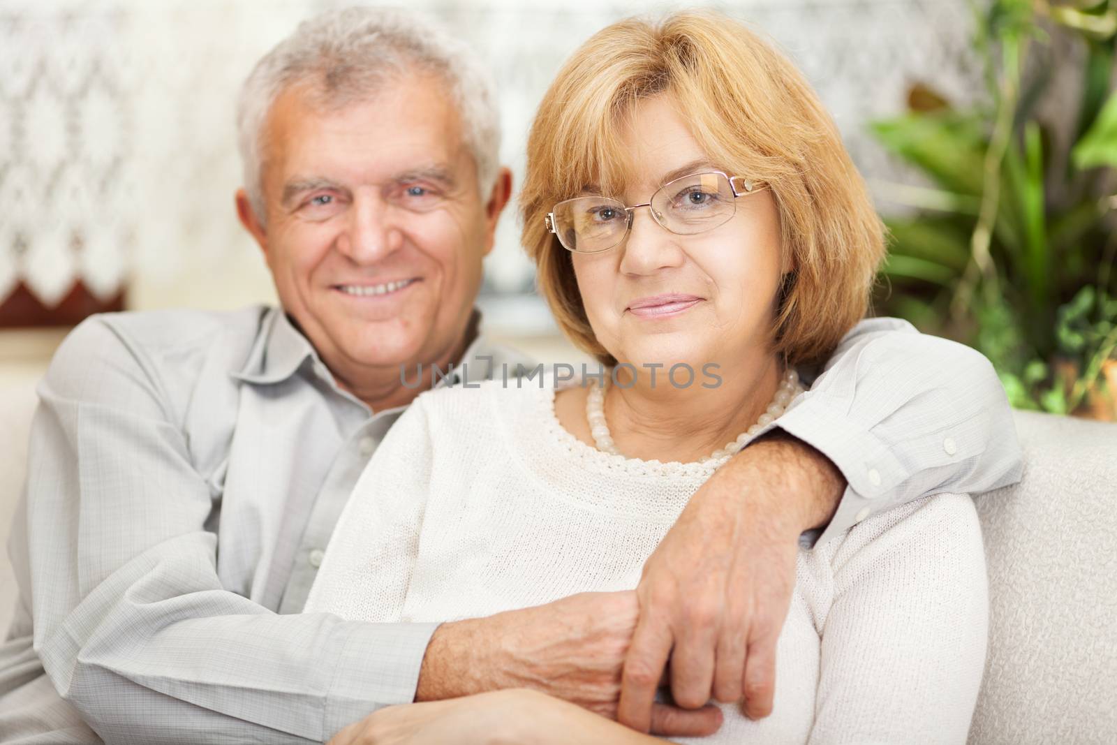 Happy senior couple in love sitting in living room