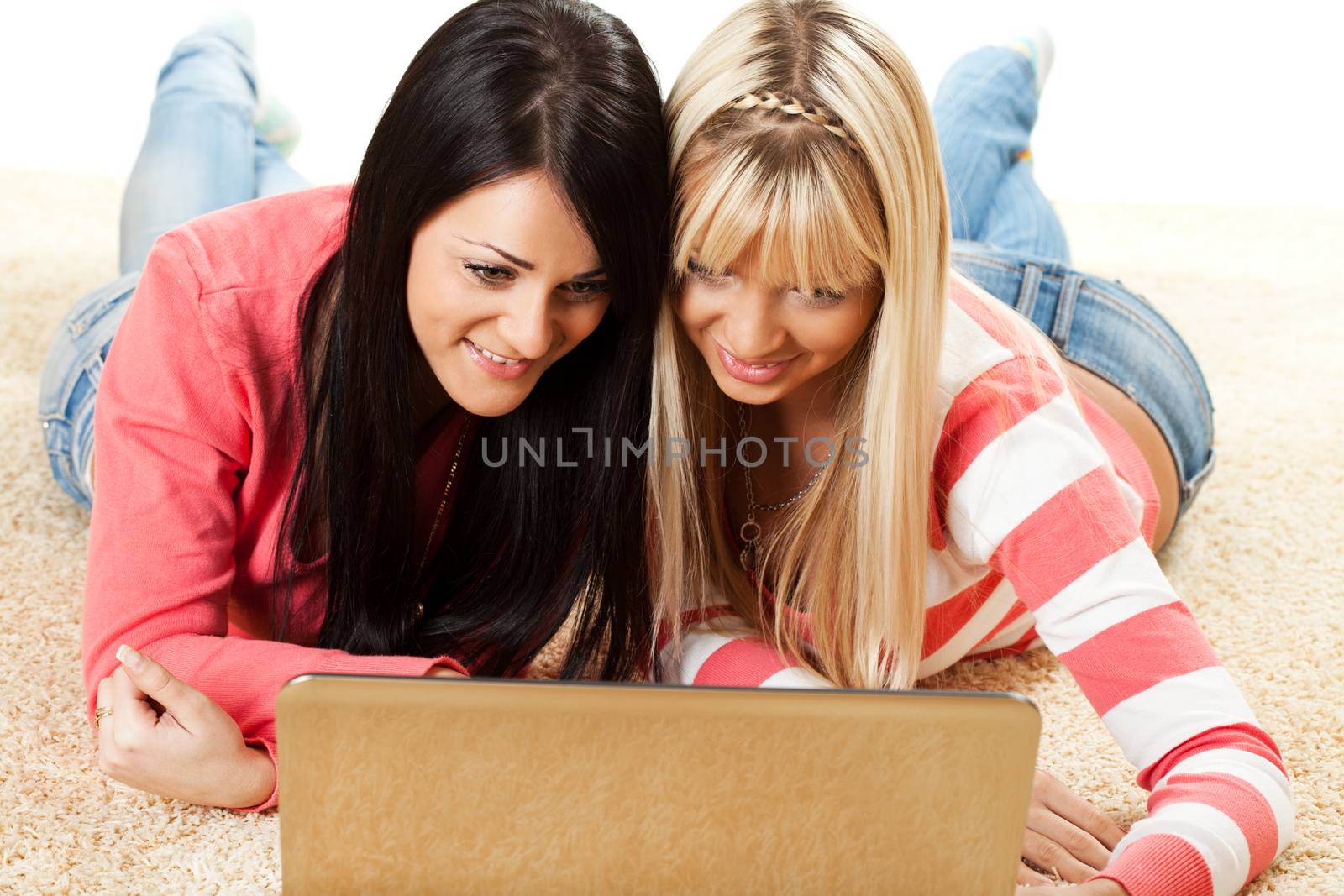 Beautiful girls with laptop at home surfing on the internet